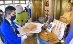 ビリケンさんに「星空舞」の豊作を祈願する松村所長＝１３日、大阪市浪速区の通天閣