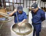 　作業を見守る杜氏の石川達也さん（右）＝１１月、茨城県大洗町の「月の井酒造店」