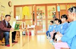 但馬牛に関する紙芝居に熱心に聞き入る園児たち＝２３日、香美町小代区実山の小代認定こども園