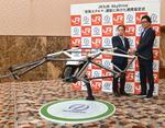 　空飛ぶクルマの模型を前に握手するスカイドライブの福沢知浩ＣＥＯ（右）とＪＲ九州の古宮洋二社長＝４日午後、東京都千代田区