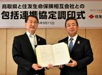 協定書を交わす住友生命の高田社長（右）と平井知事＝１１日、鳥取県庁