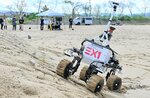 砂地の急斜面で走行する月面探査車＝１４日、鳥取市浜坂の鳥取砂丘月面実証フィールド「ルナテラス」