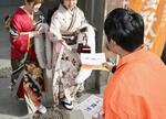 　奈良県大和高田市の成人式会場前で、参政党のビラを配る男性。「問題が山積みで、僕らの世代にのしかかっている」＝１月