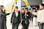 在学生たちから花のアーチで歓迎される新入生＝３日、豊岡市山王町の芸文観光大