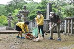  墓所内の落ち葉を集める丸山会長（中央）ら 