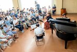 寄贈されたグランドピアノの音色に聴き入る市民ら