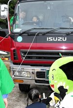 大型トラックの運転席に座って死角の範囲を確認する児童