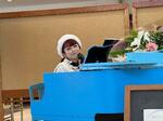 　ピアノ弾き語りプチライブの会場で開演前にピアノの前に座る、にかもとりかさん＝盛岡市、２０２３年１１月、提供写真