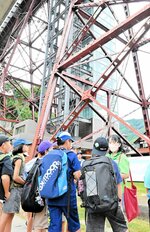 ガイドの山口さん（右奥）から余部駅の歴史などについて説明を聞く子どもたち＝１９日、香美町香住区余部