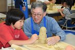 土器づくりの会のメンバーに教わりながらはにわづくりに挑戦する子ども（左）＝４日、大山町妻木のむきばんだ史跡公園