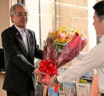 職員から贈られた花束を受け取る金児町長（左）＝２０日、智頭町智頭の町役場