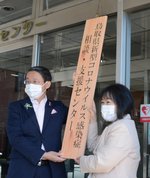 新しい看板を設置する松本会長（右）と平井知事＝９日、鳥取市江津