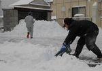 駐車場の雪をかく人たち＝24日午前７時53分、境港市湊町