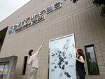 　カメイアリーナ仙台で展示されている「ハイキュー！！」の記念モニュメントを前にポーズをとるファン＝２６日、仙台市