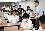 松田教諭（右上）の英語の授業を見学する参加者ら