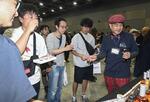 　ウイスキートーク福岡」で試飲を楽しむ来場者。右端は江井ケ嶋酒造の中村裕司ウイスキー蒸留所長＝６月、福岡市