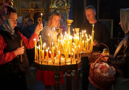 　５日、ウクライナ・キーウの聖ミハイル黄金ドーム修道院で、ろうそくをともし祈る市民ら（共同）