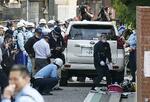 　事故を起こしたとみられる車両を調べる警察官ら＝１日午後２時４２分、大阪市西成区