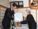 　県職員から林静さんの遺骨を受け取る、次女の来栖美智子さん（右）＝２４日午後、茨城県茨城町