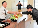 川越組合長（左）と握手する技能実習生＝３日、新温泉町の浜坂漁協