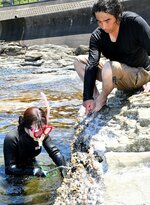 長戸代表（右）の指導を受けながらイガイを岩礁からはぎ取る佑里さん＝１８日、鳥取市青谷町青谷の夏泊海岸