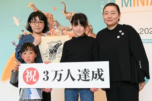 青戸館長（右）から記念品を贈られた園山さん親子＝２３日、米子市美術館