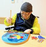 　「Ｓｍｉｌｅ　ｔｏｙ」の玩具で遊ぶ利用者（銀鳥産業提供）