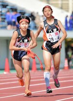 女子　八頭は４区宮脇（右）から３位でたすきを受けたアンカーの鵜飼が首位に躍り出る＝ヤマタスポーツパーク陸上競技場