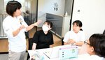 企業担当者（左）からアドバイスを受けながら企画立案に挑戦する学生ら＝２４日、倉吉市巌城の流通