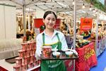 　無形文化遺産登録を祝うイベントでトムヤムクン味の即席麺をＰＲする女性スタッフ＝２０２４年１２月、タイ・バンコク（共同）
