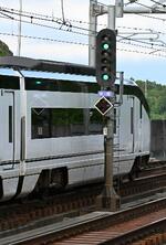 　青２灯を出す信号機と通過するスカイライナー