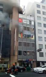 　事件発生当日、煙を上げる大阪・北新地のビル火災現場＝２０２１年１２月１７日（通行人提供）