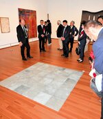 【美術は奥深い】　正方形の亜鉛板を床に敷き詰めたミニマル・アート「亜鉛と亜鉛のプレーン」（カール・アンドレ）を見つめる内覧会出席者ら＝３月２８日、県立美術館