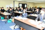 メモをとりながら真剣に話を聞く新入行員