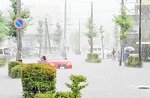 冠水した道路で立ち往生する車。内水氾濫により各地で道路が冠水した＝１３日、鳥取市富安２丁目