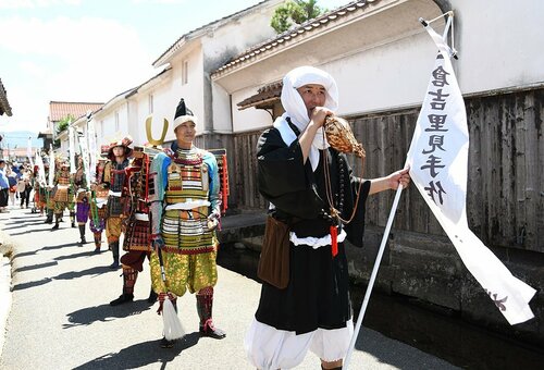 法衣や甲冑に身を包み、白壁土蔵群内を進む時代行列＝３日、倉吉市新町１丁目