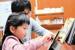 タブレットを操作してプログラミングに挑戦する参加者＝新温泉町浜坂の加藤文太郎記念図書館