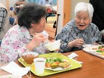 おいしい食事を笑顔で味わう住民たち