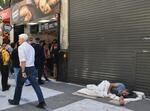 　アルゼンチン・ブエノスアイレス中心部の路上で寝る男性＝１６日（共同）