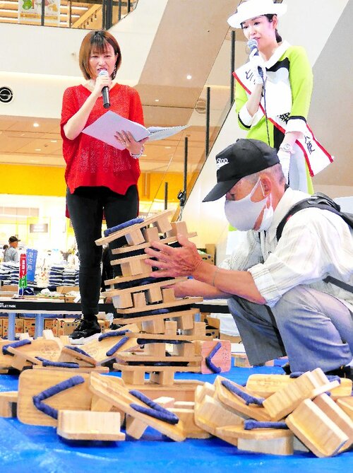 ステージ上で下駄を積む数を競う参加者＝２４日、門真市