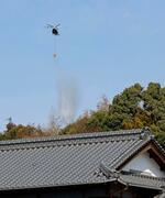 　愛媛県今治市の山林火災現場で、上空から散水するヘリコプター＝２９日午前９時３３分