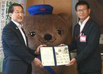平井知事（左）にオリジナルフレーム切手を手渡した砂支社長＝２７日、鳥取県庁