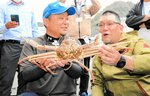 最高値の１千万円で買い取られた松葉ガニと植村さん（右）＝６日、兵庫県新温泉町芦屋の浜坂漁港