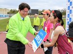  上位入賞者（右）に副賞を手渡す田村営業本部長＝１７日、鳥取市のヤマタスポーツパーク陸上競技場 