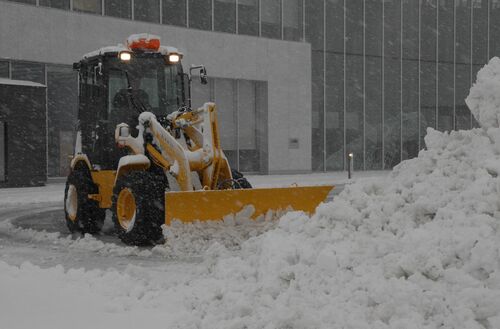 境港市民交流センター前の雪をかく除雪車＝24日午前８時２分、境港市上道町