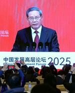 　「中国発展フォーラム」で演説する中国の李強首相を映す大型画面＝２３日、北京（共同）