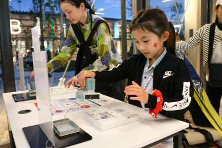 　大阪・関西万博の会場でスタンプを押す子ども＝大阪市此花区の夢洲