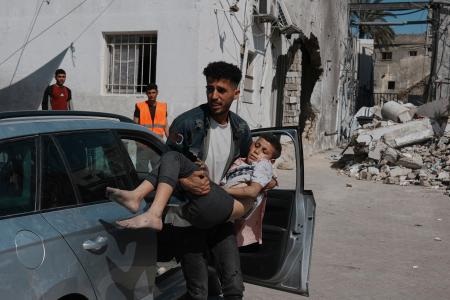 　３０日、イスラエル軍の攻撃後、負傷し病院に運ばれる少年＝パレスチナ自治区ガザ北部ガザ市（ＡＰ＝共同）