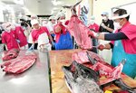豪快にさばかれるクロマグロに見入る生徒たち＝１６日、境港市竹内町