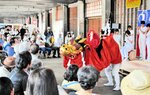 大勢の観客の前で伝統芸能の麒麟獅子舞を披露する浜坂高の生徒ら＝１５日、新温泉町諸寄の浜坂漁協諸寄セリ場